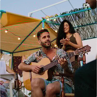 Man playing acoustic guitar with singer in background
