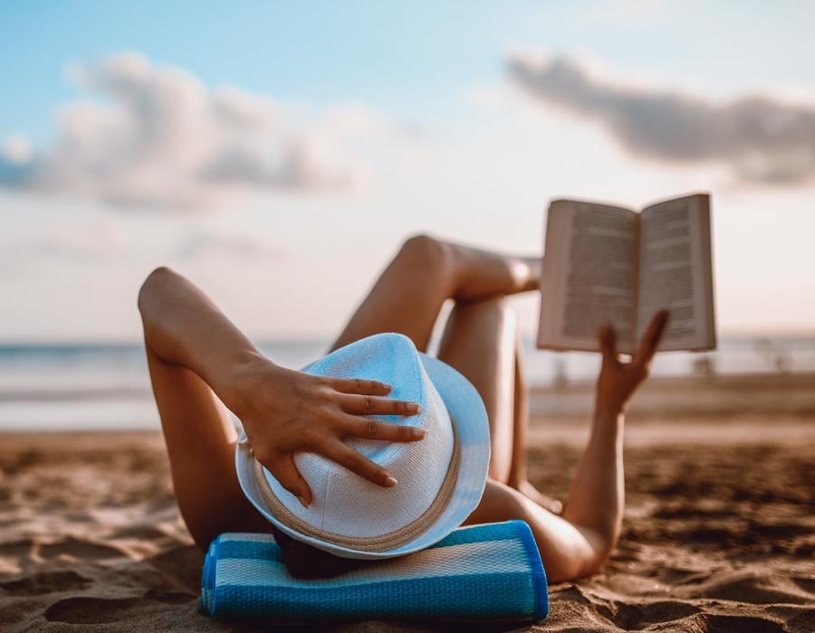 Woman reading book on beach