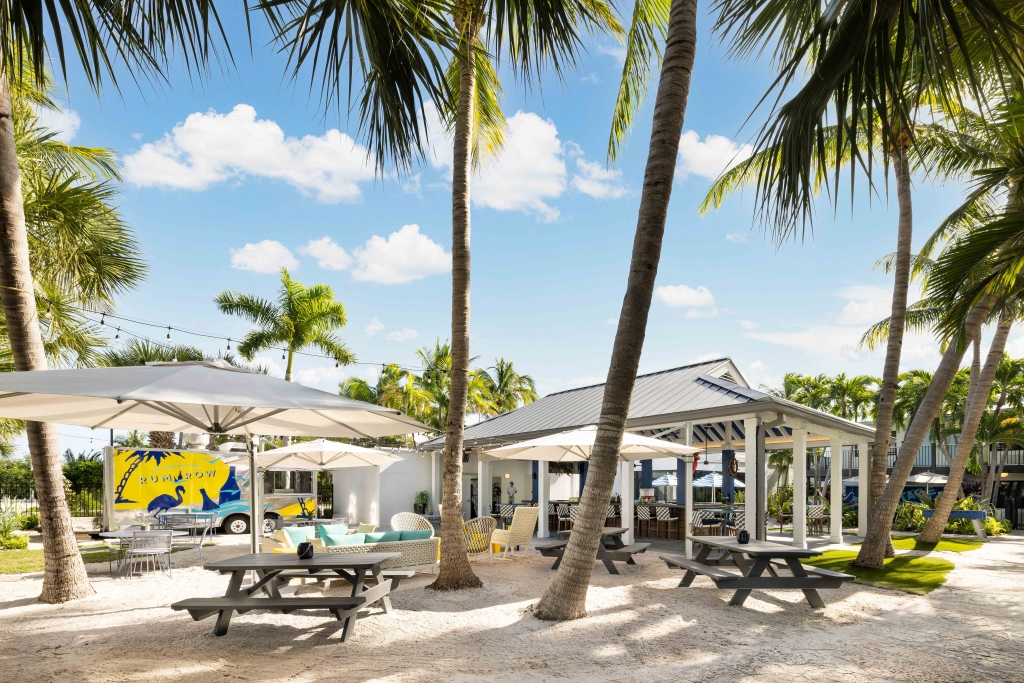 The Backyard Pool & Social Club at Blue Flamingo Resort in Key West, featuring lounge areas, food, outdoor bars, games, and poolside amenities