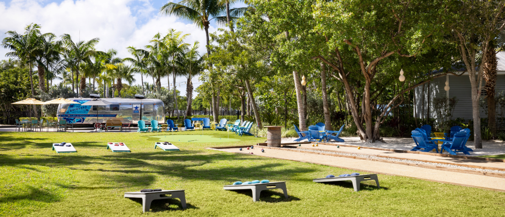 Outdoor lawn game area with cornhole, bocce courts, and Adirondack chairs at Blue Flamingo Resort Key West.