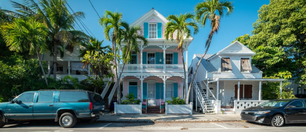 Colorful historic Key West houses and palm trees along a sunny residential street