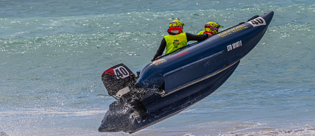 Offshore racing powerboat catching air above ocean waves